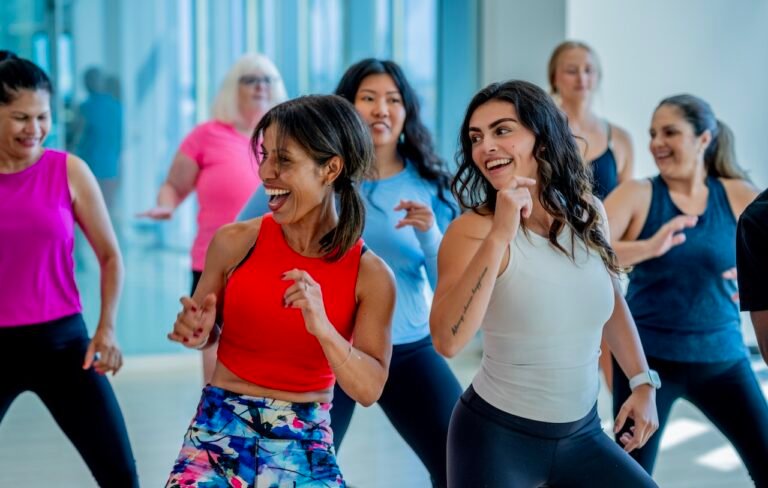 A large group of adults are seen in a community together, as they participate in a dance class.